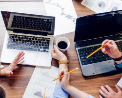 people-sitting-desk-with-laptops-working